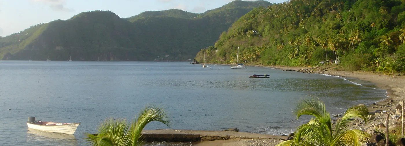 Calm water, palms and green hills at Malgretout Beach near Soufriere, Saint Lucia